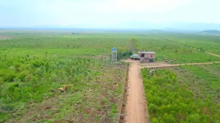 Foreign investor discussing land ownership options with Cambodian advisor in a rural development area